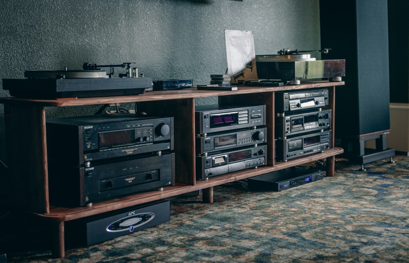 Installation hi-fi avec platine vinyle et amplificateurs sur un meuble en bois