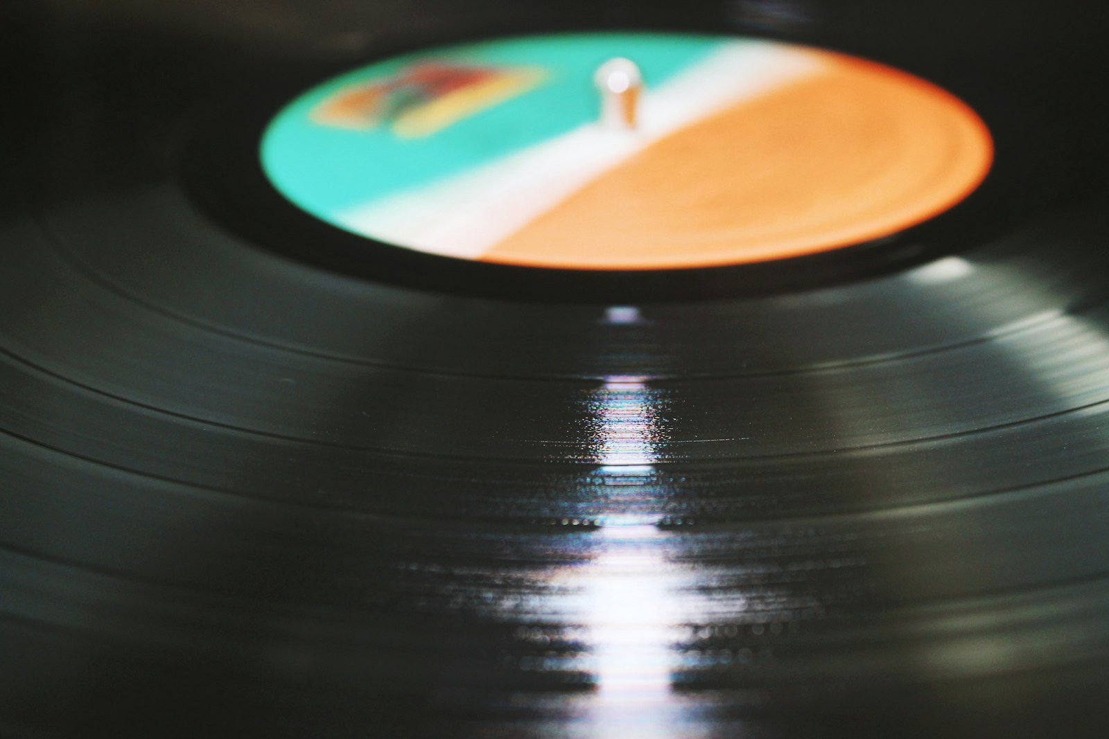 Gros plan sur les sillons d’un disque vinyle sous la lumière